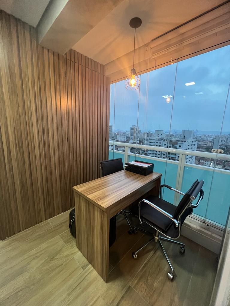 Espaço de atendimento e consulta do consultório 2, com mesa de madeira e vista de Santos.